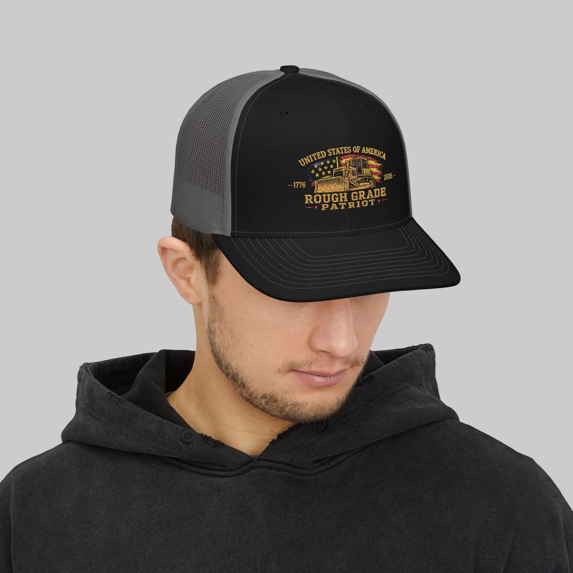 Person wearing a black and gray cap with a logo on a white background