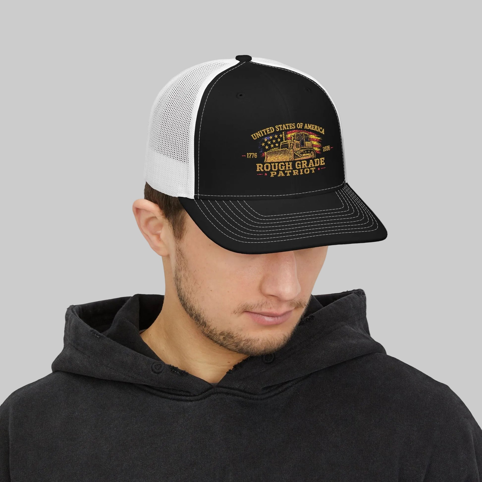 Man wearing a black and white trucker hat with a logo on a white background